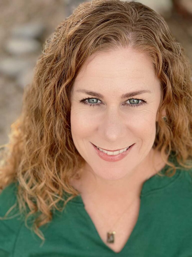 A portrait of Nicole Valdez, a friendly and professional therapist, wearing a green top with a warm smile.